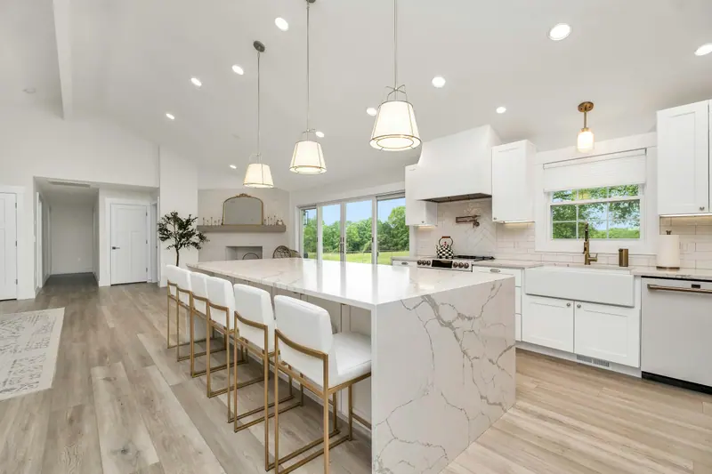 Bright remodeled kitchen with a marble waterfall island